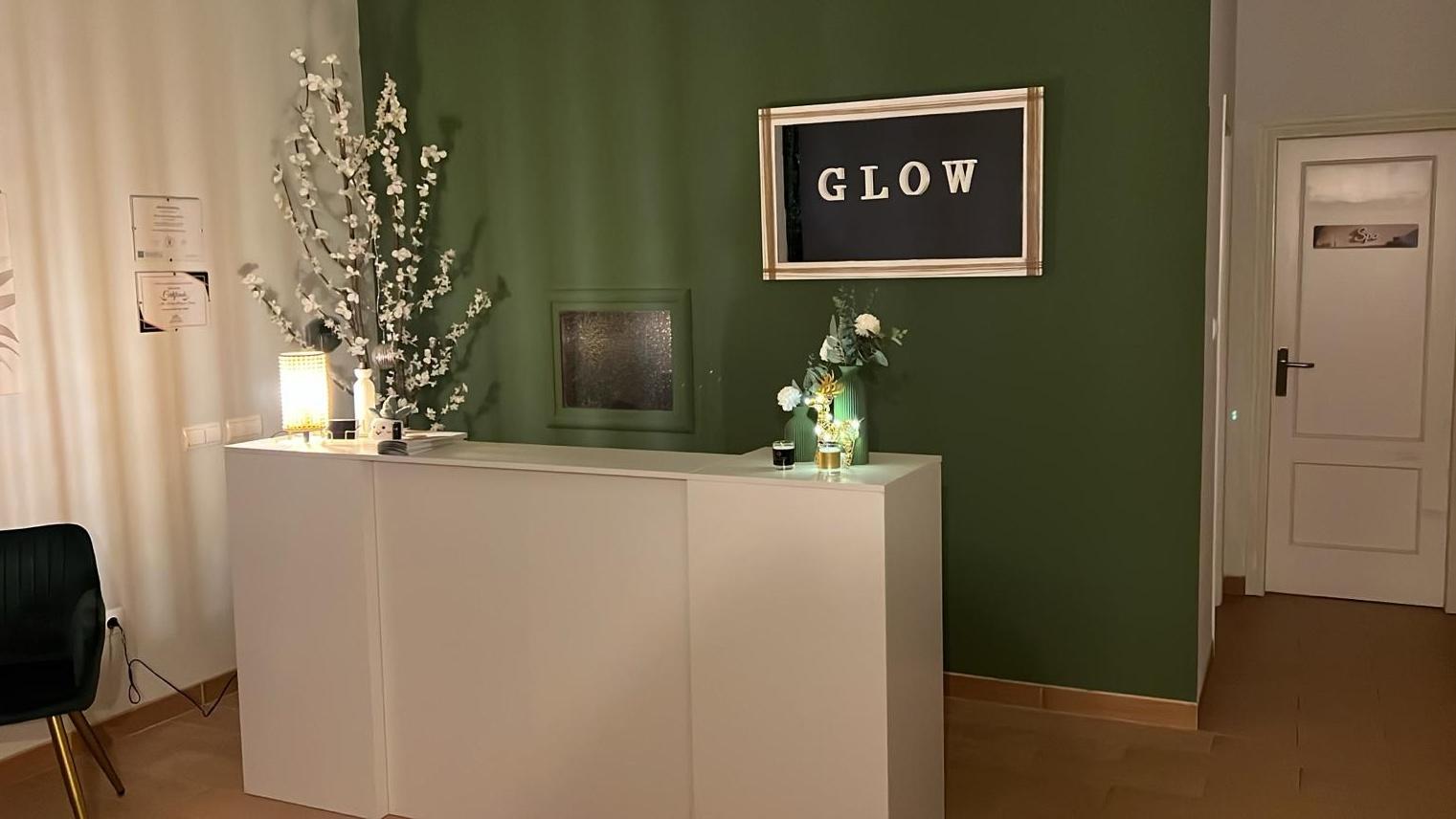 Recepción y zona de espera de Glow Head Spa, con luz cálida y plantas.